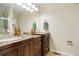 Bathroom featuring double sinks with dark wood cabinets, granite countertops, and modern fixtures at 17623 Cornish Pl, Parker, CO 80134