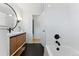 Contemporary bathroom with tub, shower with white subway tiles, modern vanity and stylish black hexagon tile flooring at 1920 S Niagara St, Denver, CO 80224