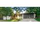 Charming home featuring lush greenery, a modern glass garage door, and a well-manicured lawn at 1920 S Niagara St, Denver, CO 80224