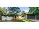 Inviting home exterior with mature trees, a glass-paneled garage, a tidy lawn, and bright green chairs at 1920 S Niagara St, Denver, CO 80224