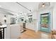 Bright kitchen with stainless steel appliances, white cabinetry, and a modern blue exterior door at 1920 S Niagara St, Denver, CO 80224