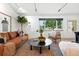 Comfortable living room featuring a cozy leather sofa, large window, and stylish mid-century modern furnishings at 1920 S Niagara St, Denver, CO 80224