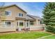 Back of the home featuring a large lawn, trees, and a patio at 3179 S Indiana St, Lakewood, CO 80228