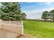 Backyard featuring a large lawn, mature trees, and a white fence at 3179 S Indiana St, Lakewood, CO 80228