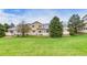Rear exterior featuring large lawn, patios, and a partial view of the back of the home at 3179 S Indiana St, Lakewood, CO 80228
