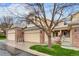 Front exterior featuring a two-car garage and a small, decorative front porch at 3179 S Indiana St, Lakewood, CO 80228