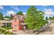 Beautiful vintage home with a red brick exterior, a covered porch, and mature landscaping at 805 5Th St, Fort Lupton, CO 80621