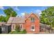 Charming red brick two-story home with a mix of brick and wood exterior, and a beautiful lawn at 805 5Th St, Fort Lupton, CO 80621