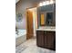 Bathroom featuring a large soaking tub, vanity with granite countertops, and tiled floors at 17046 Wellington Dr, Parker, CO 80134