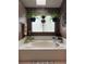 Bathroom with a white tiled bathtub, potted plants, and a skylight above at 17046 Wellington Dr, Parker, CO 80134