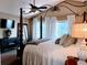 Cozy bedroom featuring a four-poster bed, plush pillows, and bright natural light from the windows at 17046 Wellington Dr, Parker, CO 80134