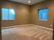 Bedroom with plush carpet, brown walls, and two windows providing natural light at 17046 Wellington Dr, Parker, CO 80134