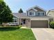 Charming two-story home with a well-maintained lawn, brick accents, and an attached two-car garage at 17046 Wellington Dr, Parker, CO 80134