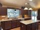 Well-lit kitchen features a large island, granite countertops, brown cabinetry, and stainless steel appliances at 17046 Wellington Dr, Parker, CO 80134