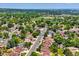An aerial view showcases the home nestled in a neighborhood with mature trees and a park nearby at 6441 W 73Rd Pl, Arvada, CO 80003
