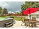 Backyard area featuring patio, hot tub, red umbrella and shed surrounded by mature trees at 6441 W 73Rd Pl, Arvada, CO 80003