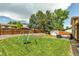 A spacious lawn with mature trees, a playground, and a partially-fenced yard offer plenty of room for outdoor activities at 6441 W 73Rd Pl, Arvada, CO 80003