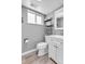 Renovated bathroom with white vanity, toilet, modern mirror, and sleek shelving at 6441 W 73Rd Pl, Arvada, CO 80003