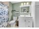 Bathroom with vanity, toilet, tiled floors, butterfly-themed shower curtain and green walls at 6441 W 73Rd Pl, Arvada, CO 80003