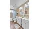 Bathroom featuring double vanity, wood floors, bathtub shower, and warm beige walls at 6441 W 73Rd Pl, Arvada, CO 80003
