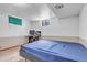 Simple basement bedroom with carpet, drop ceiling, desk and blue blanket on bed at 6441 W 73Rd Pl, Arvada, CO 80003