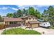 Charming two-story home with a well-maintained lawn, mature trees, attached garage, and RV parking at 6441 W 73Rd Pl, Arvada, CO 80003