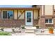A welcoming front entrance features brick accents, flower pots, and updated front door at 6441 W 73Rd Pl, Arvada, CO 80003