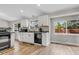 Bright kitchen with white cabinets, stainless steel appliances, and laminate floor at 6441 W 73Rd Pl, Arvada, CO 80003