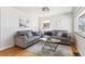 Bright living area with hardwood floors, two couches, modern decor, and ample natural light at 3258 Niagara St, Denver, CO 80207