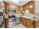 Bright kitchen with stainless steel appliances, tile backsplash, and light wood cabinets at 715 S Alton Way # 5D, Denver, CO 80247