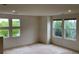 Bright bedroom featuring multiple windows with scenic views, complemented by neutral-toned walls and plush carpeting at 11947 Riverstone Cir # 7F, Henderson, CO 80640