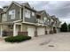 Row of townhouses each with a garage, balcony, and brick facade, showing well-maintained exteriors and curb appeal at 11947 Riverstone Cir # 7F, Henderson, CO 80640
