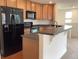 Updated kitchen featuring modern appliances, wooden cabinets, and a convenient breakfast bar at 11947 Riverstone Cir # 7F, Henderson, CO 80640