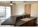 Kitchen with sink and dishwasher in breakfast bar. Sliding door leads to outside deck at 11947 Riverstone Cir # 7F, Henderson, CO 80640