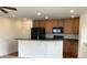 Kitchen with stainless steel appliances, wooden cabinetry, and breakfast bar for extra seating at 11947 Riverstone Cir # 7F, Henderson, CO 80640