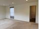Well-lit living room with neutral carpet and natural light, leading to bathroom at 11947 Riverstone Cir # 7F, Henderson, CO 80640