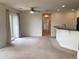 Open-concept living area boasts neutral carpeting, ceiling fan, and sliding glass doors to the outside at 11947 Riverstone Cir # 7F, Henderson, CO 80640