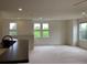 Bright living room with multiple windows offering scenic views, complemented by neutral-toned walls and plush carpeting at 11947 Riverstone Cir # 7F, Henderson, CO 80640