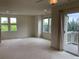 Bright and spacious living room with multiple windows, balcony access, and neutral walls at 11947 Riverstone Cir # 7F, Henderson, CO 80640