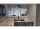 Open kitchen featuring stone countertops, modern faucet, view of living room and staircase at 1818 S Quebec Way # 5-7, Denver, CO 80231