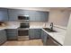 Kitchen with grey cabinets, stainless steel appliances, stylish countertops, and wood flooring at 1818 S Quebec Way # 5-7, Denver, CO 80231