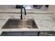 Stainless steel sink with modern faucet set into marble countertops at 1818 S Quebec Way # 5-7, Denver, CO 80231