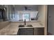 Kitchen with marble countertops, sink, and cabinets with view to the living room at 1818 S Quebec Way # 5-7, Denver, CO 80231