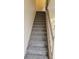 Carpeted staircase with neutral walls and a light-colored banister at 1818 S Quebec Way # 5-7, Denver, CO 80231