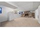 Spacious basement featuring a stone fireplace, refrigerator and neutral carpet at 6651 S Dudley Ct, Littleton, CO 80123