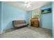 Bright bedroom featuring light blue walls, a futon, ceiling fan and a wood desk, perfect for a home office at 6651 S Dudley Ct, Littleton, CO 80123