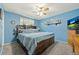 Cozy bedroom with blue walls, a ceiling fan, and a large bed with built-in storage at 6651 S Dudley Ct, Littleton, CO 80123