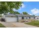 Charming single-story home with an attached garage and well-maintained landscaping at 6651 S Dudley Ct, Littleton, CO 80123