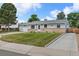 Well-maintained single-Gathering home with a manicured lawn and long driveway leading to the attached garage at 6651 S Dudley Ct, Littleton, CO 80123