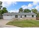 Charming single-story home with light-blue siding, brick accents, well-kept lawn, and a driveway leading to an attached garage at 6651 S Dudley Ct, Littleton, CO 80123